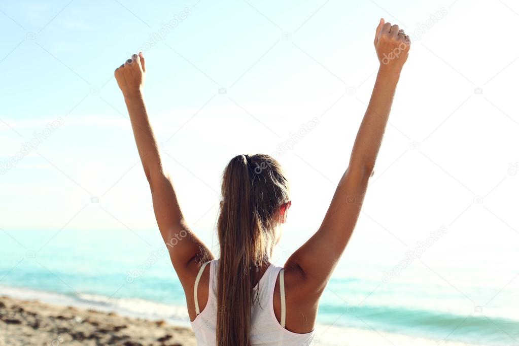 Successful sportswoman raising arms