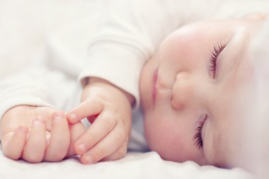 Beyaz üzerinde uyuyan güzel bir bebeğin yakın plan portresi