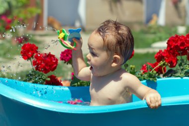 şirin komik bebek erkek çiçekler arasında yeşil çim üzerinde açık banyo