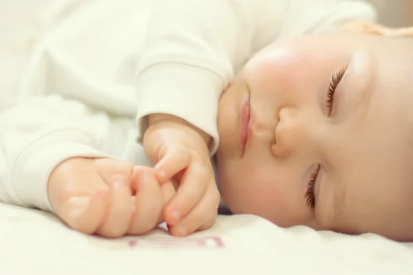 Retrato de cerca de un hermoso bebé dormido en blanco — Foto de Stock