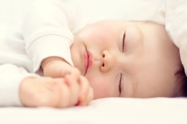 Retrato de cerca de un hermoso bebé dormido en blanco —  Fotos de Stock