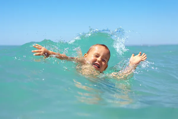 Vtipný chlapeček plavající ve vlnách — Stock fotografie