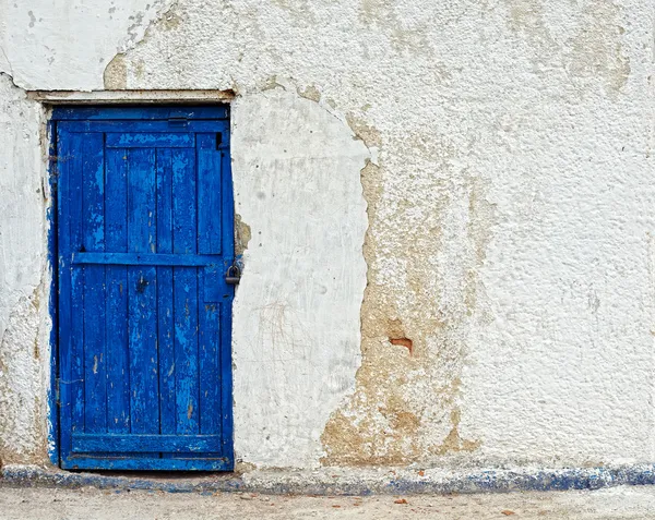 Casa velha parede branca com porta azul — Fotografia de Stock