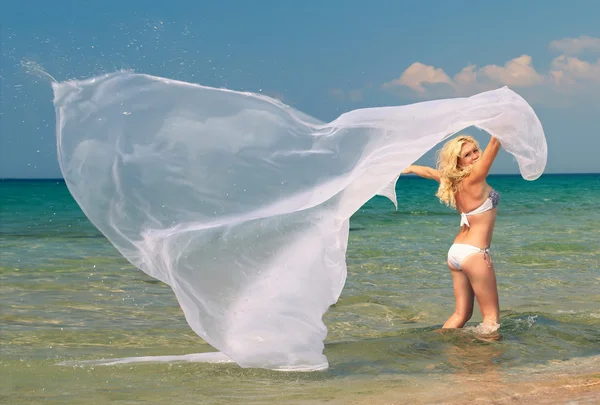 Belle femme blonde en maillot de bain blanc et panache debout dans l'eau de mer — Photo