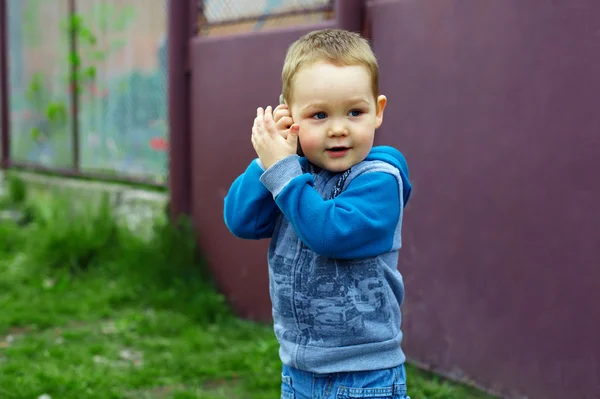 Ładny chłopczyk naśladować, rozmawia przez telefon podczas gry o — Zdjęcie stockowe