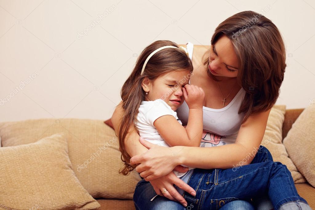 prety mother soothing and hugging crying baby girl