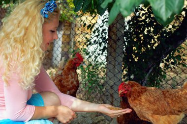 genç gülümseyen kadın arka açık tavuk besleme