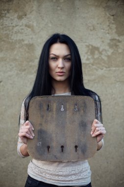 Grunge duvar ve tutun önünde duran çekici ciddi esmer kadın