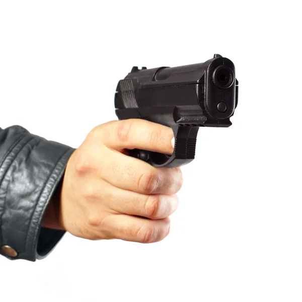 Рука в шкіряній куртці тримає пістолет ізольовано на білому — стокове фото