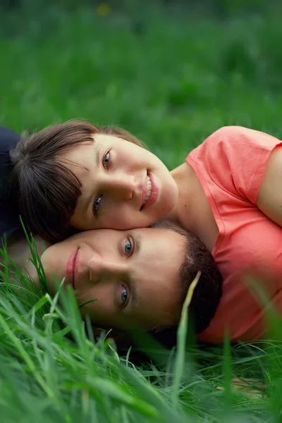 躺在草丛中的年轻夫妇 — 图库照片