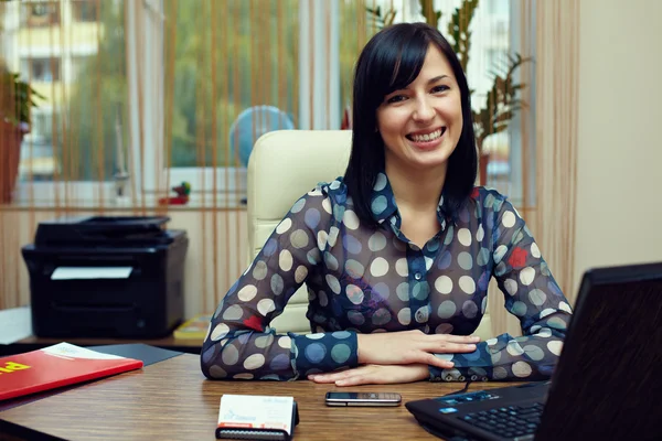 Attractive friendly woman sitting in workplace. office interior — Stock Photo, Image