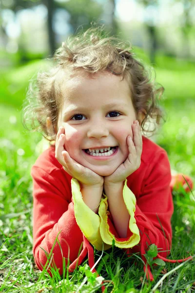 Kleines Mädchen auf Gras im Sommer Field liegen. ein bisschen Streik! — Stockfoto