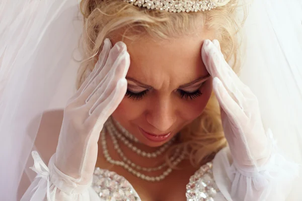 Közelkép portréja a gyönyörű menyasszony homlokát ráncolja a bajok és a fájdalom. fehér — Stock Fotó