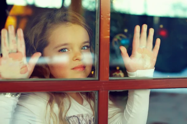 Schönes Mädchen, das aus dem Fenster schaut. Außenansicht — Stockfoto