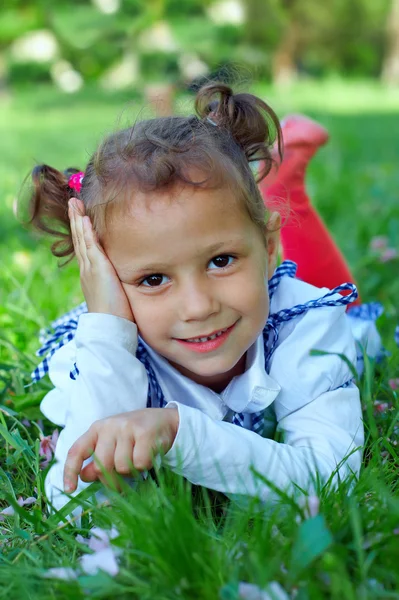 Cute dziewczynka leżący na zielonej trawie — Zdjęcie stockowe