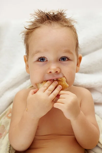 焼きたてのパンを食べて空腹おかしい男の子のクローズ アップの肖像画 — ストック写真