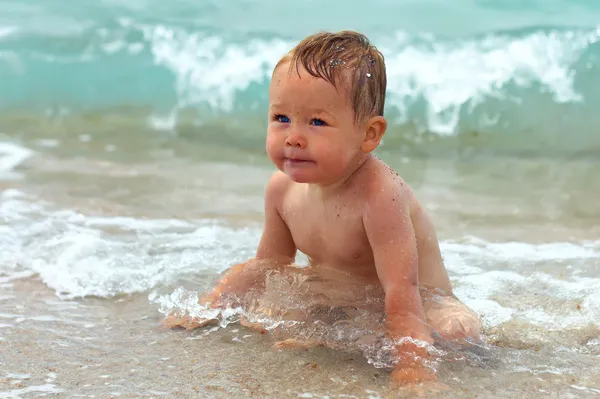 Cute baby boy sitting in freezing sea water — Stok Foto