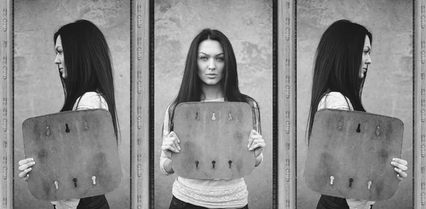 Attractive serious brunette woman holding blank board — Stock Photo, Image