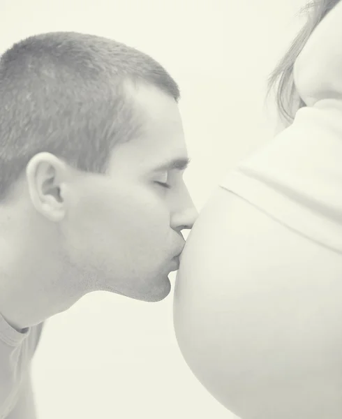 Man kissing pregnant wife belly. soft black and white portrait — Stock Photo, Image