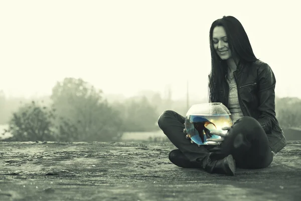 ボウルのエンゼルフィッシュと地面に美しい若い女性 — ストック写真