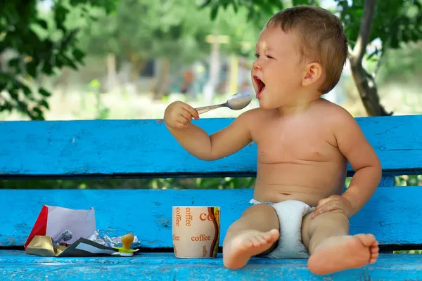 Morning ritual, small baby boy sitting on blue rural bench drinking coffee — Stock Photo, Image