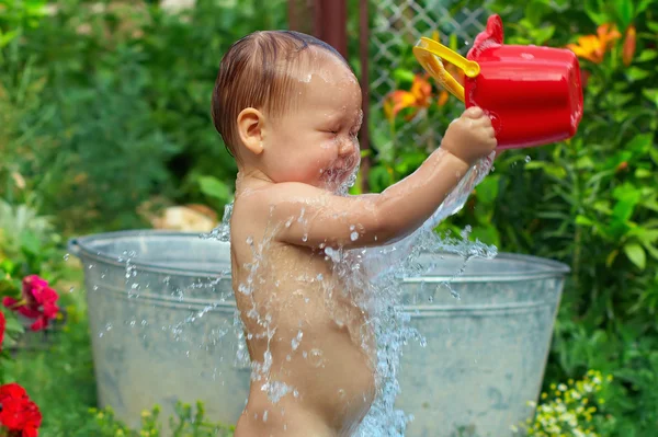 Schattige babyjongen water procedures met zomertuin — Stockfoto