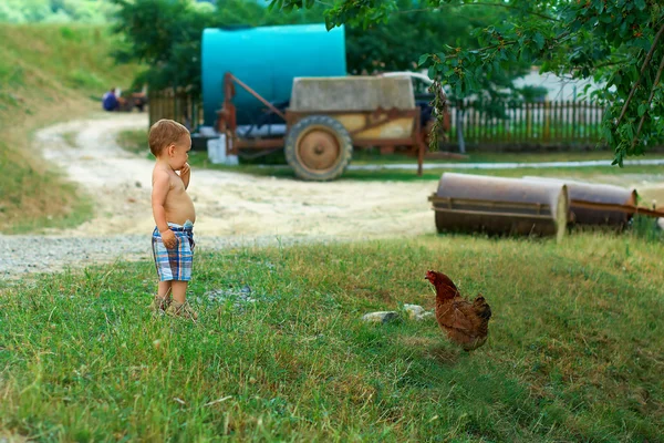 Любопытно мальчика, стоя на сельской улице — стоковое фото