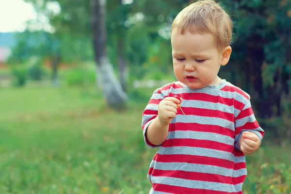 Chico lindo bebé comiendo guinda al aire libre — Foto de Stock