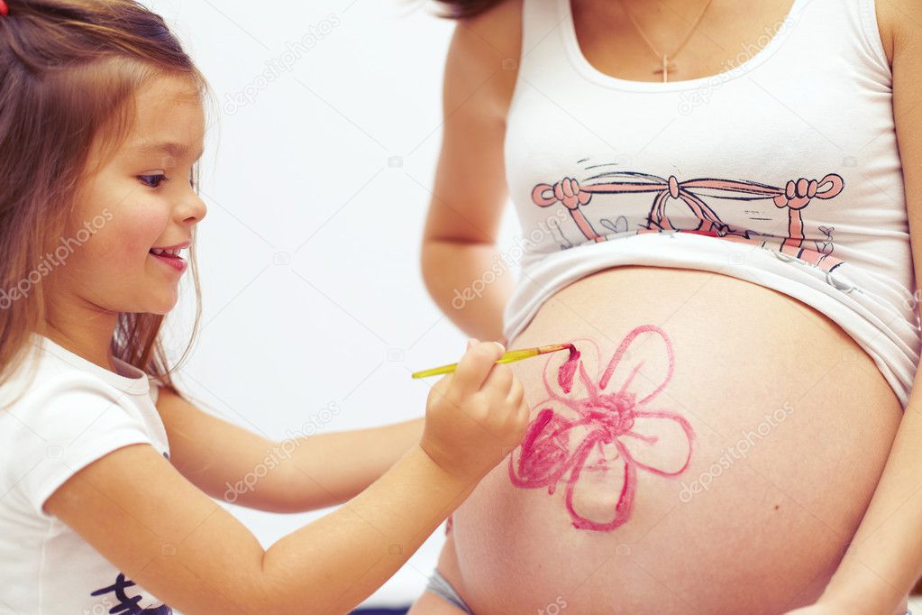 Cute daughter painting mom�s beautiful belly