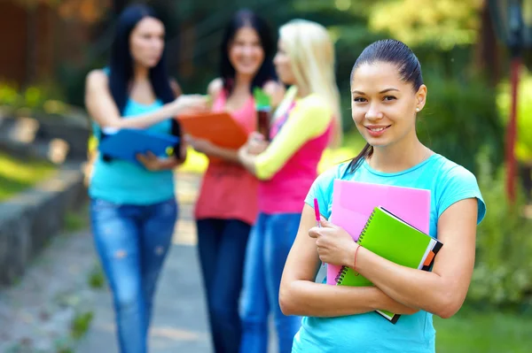 Bella studentessa all'aperto con un gruppo di sullo sfondo — Foto Stock