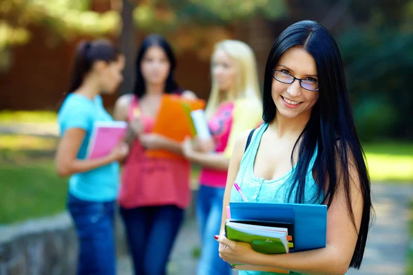 Hermosa estudiante al aire libre con un grupo de en el fondo —  Fotos de Stock