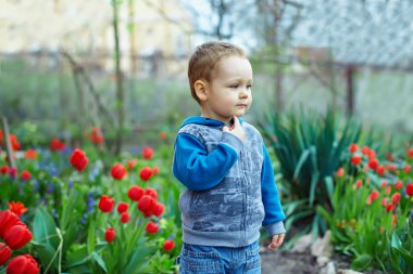 Bahar Çiçek bahçesinde duran sevimli küçük oğlu