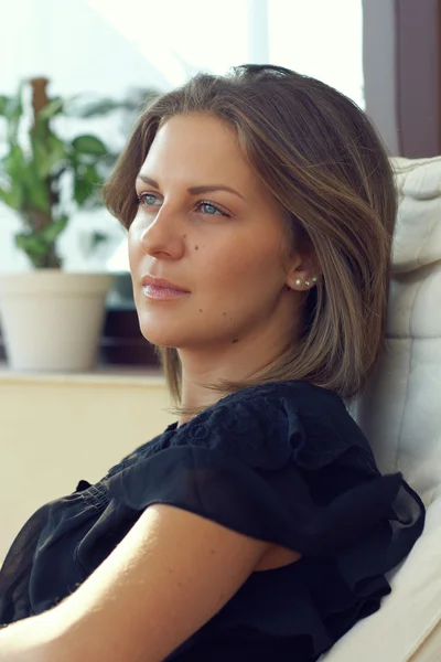 Attractive blue-eyed brunette woman sitting on terrace — Stock Photo, Image