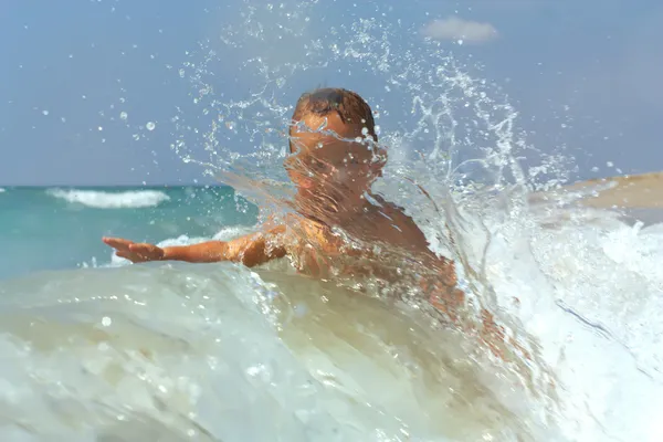 Hermoso bebé activo jugando con olas en la playa —  Fotos de Stock