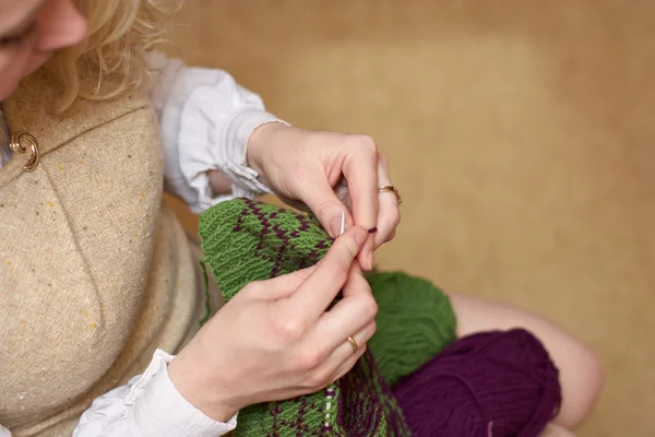 Hands of a young woman knitting with two coloured wool — Stock Photo, Image