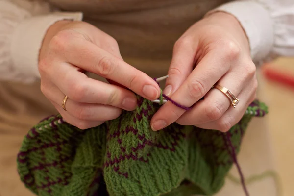 Hands of a young woman knitting with two coloured wool — Stock Photo, Image