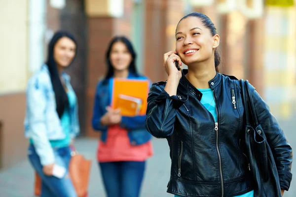 Mulher casual falando no celular, enquanto caminha na rua — Fotografia de Stock