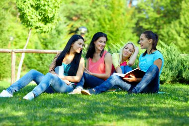 dört yeşil park okuyan öğrenci kız gülümseyerek