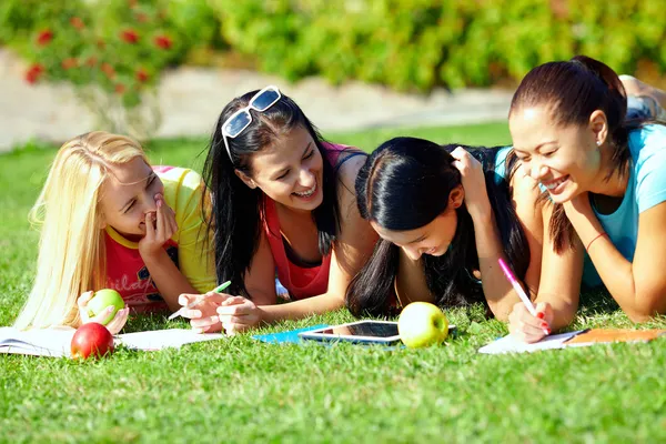 Quatro menina bonita se divertindo ao ar livre no gramado verde — Fotografia de Stock
