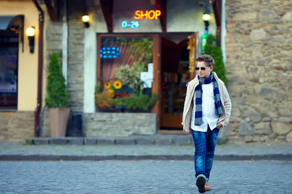 Stylish teenage boy crossing the street of old town — Stock Photo, Image