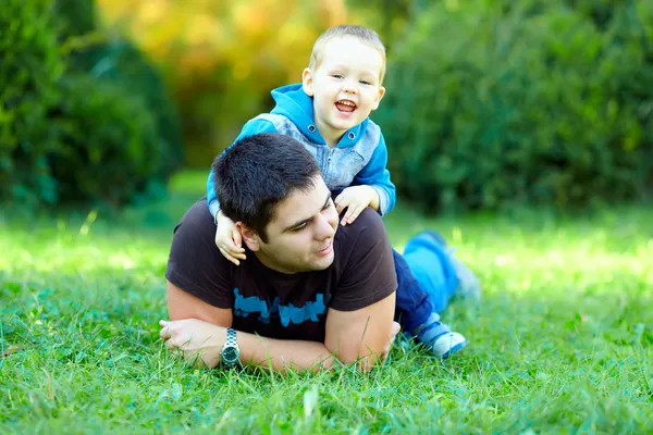 Heureux père et fils jouant sur champ vert — Photo