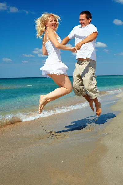 Jovem casal feliz se divertindo na praia do mar — Fotografia de Stock