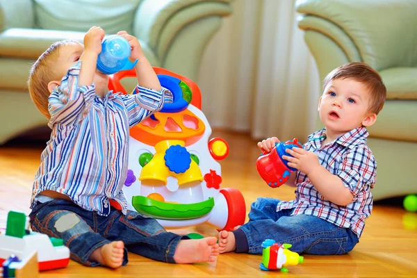 Söt rolig baby pojkar leker med leksaker hemma — Stockfoto