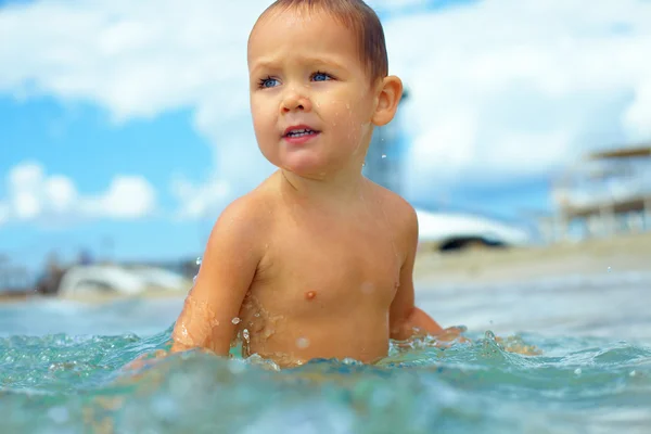 Bonito menino se divertindo na água do mar — Fotografia de Stock