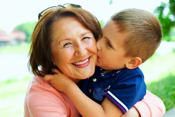 Lycklig mormor med barnbarn embracing utomhus — Stockfoto