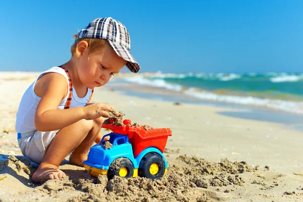 Niedliche kleine Junge spielt Spielzeug am Strand — Stockfoto