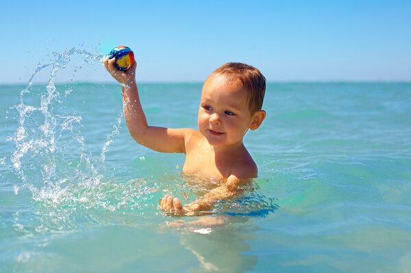 active baby playing water game in the sea