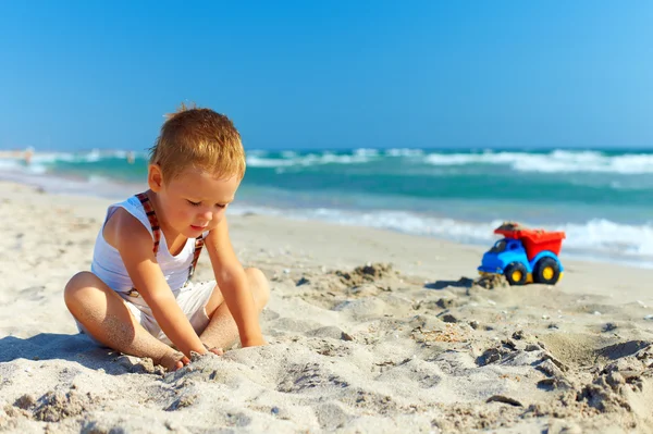 Menino bonito brincando na praia — Fotografia de Stock