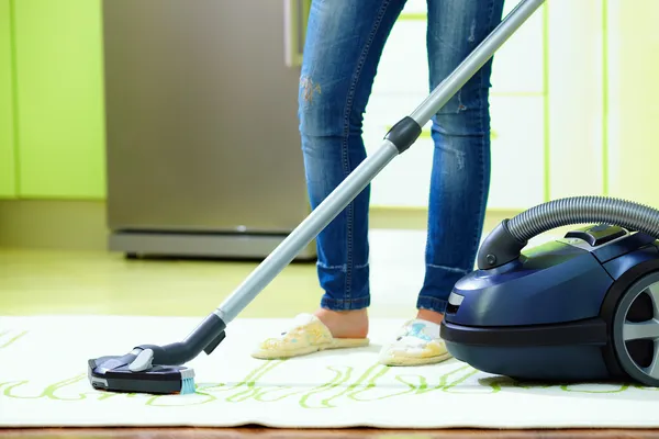 Γυναίκα καθαρισμού στο σπίτι με ηλεκτρική σκούπα — Φωτογραφία Αρχείου