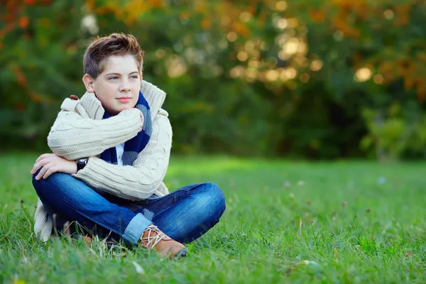 Thoughtful teenager boy in green park — Stock Photo, Image